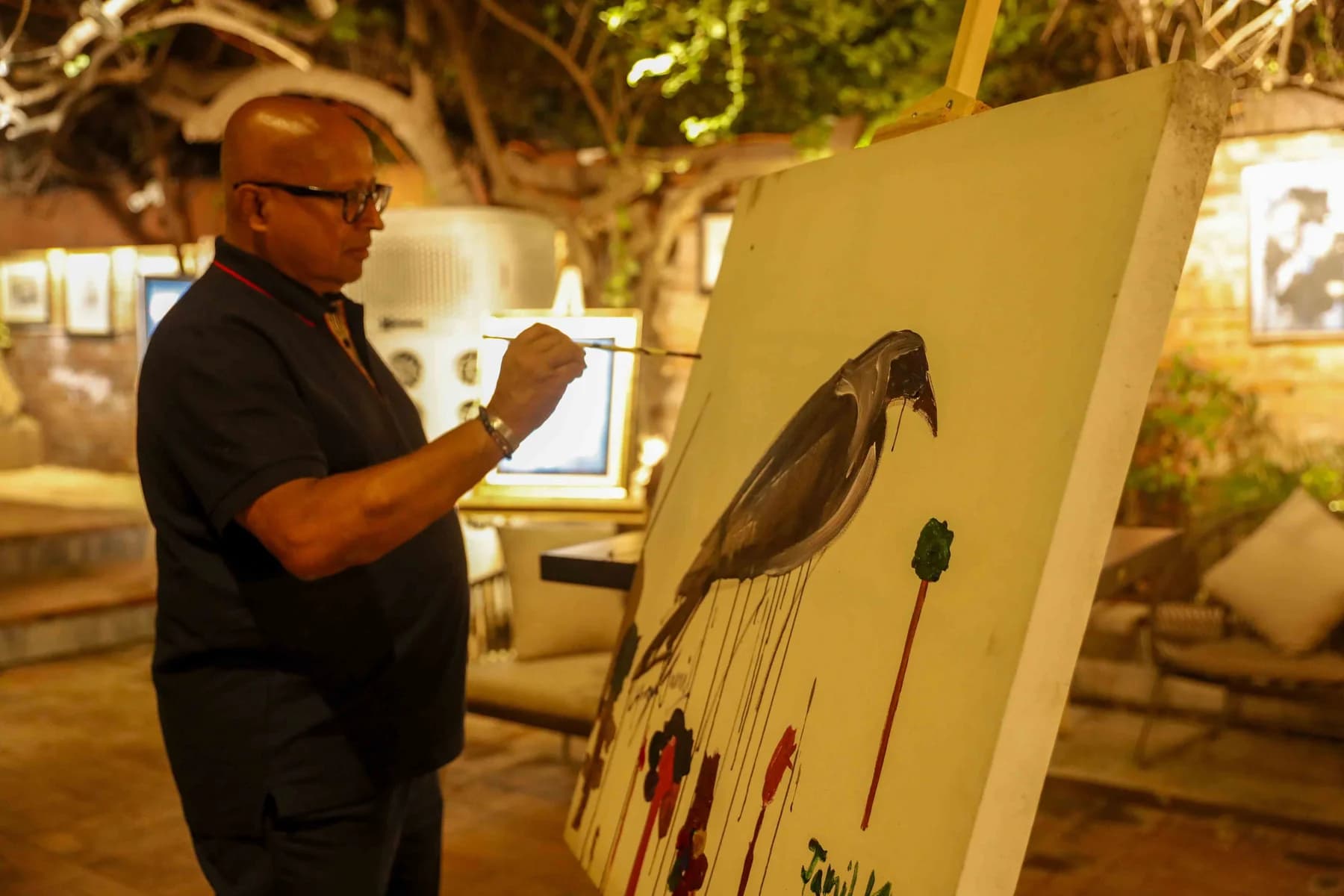A visitor looking at a work on canvas — Inspiration, a solo exhibition by Jamil Khan at Gallery Cosmos