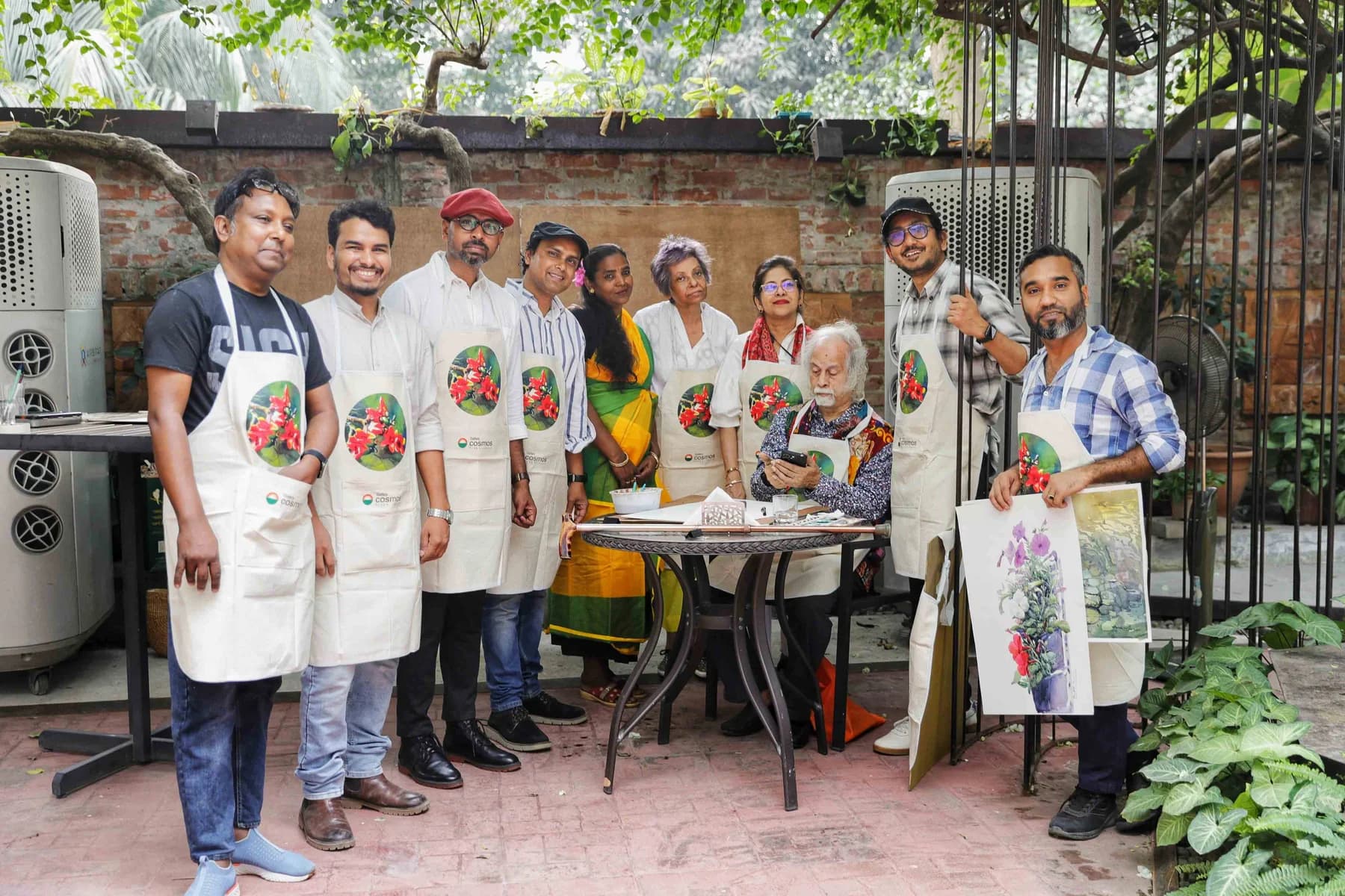 Participating artists in Gallery Cosmos aprons gathered in the courtyard