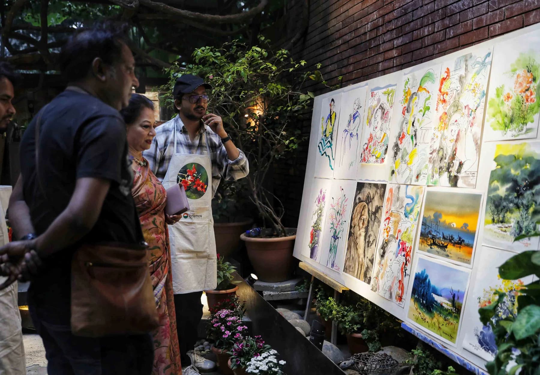 Visitors looking at watercolours displayed along the courtyard wall