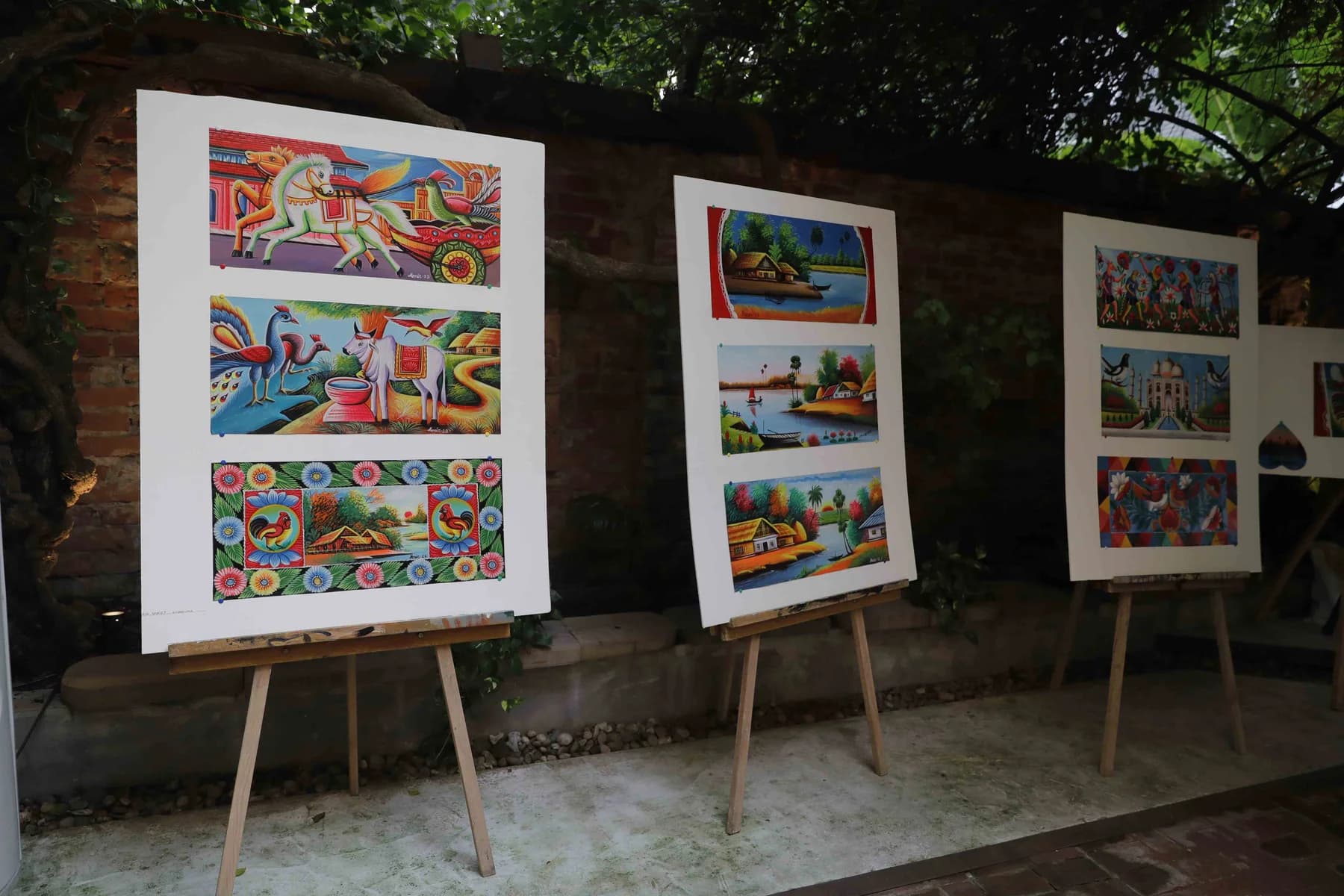 Panels shown along the garden path — Rickshaw Art Exhibition at Gallery Cosmos