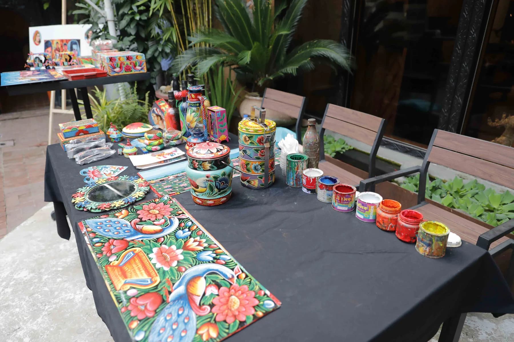 Hand-painted objects on the display table — Rickshaw Art Exhibition at Gallery Cosmos